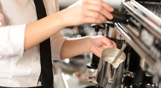 Barista steaming milk for hot chocolate 